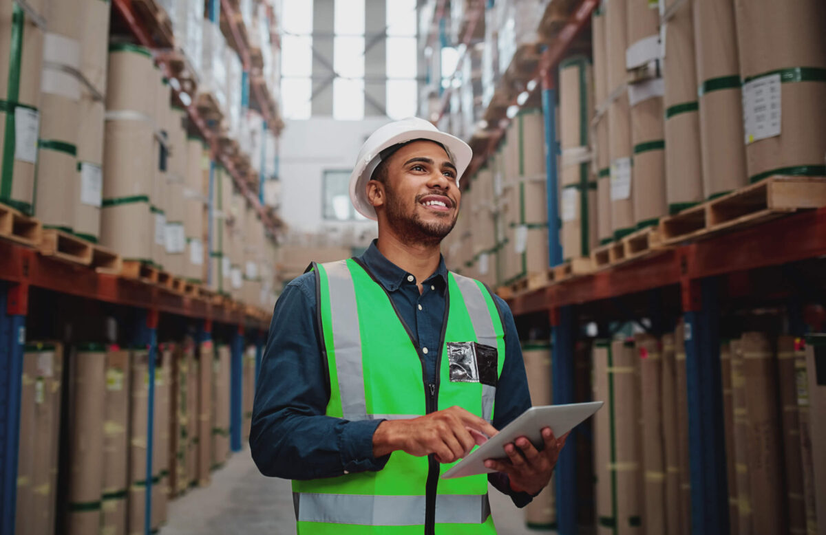 Man in a warehouse aisle smiling